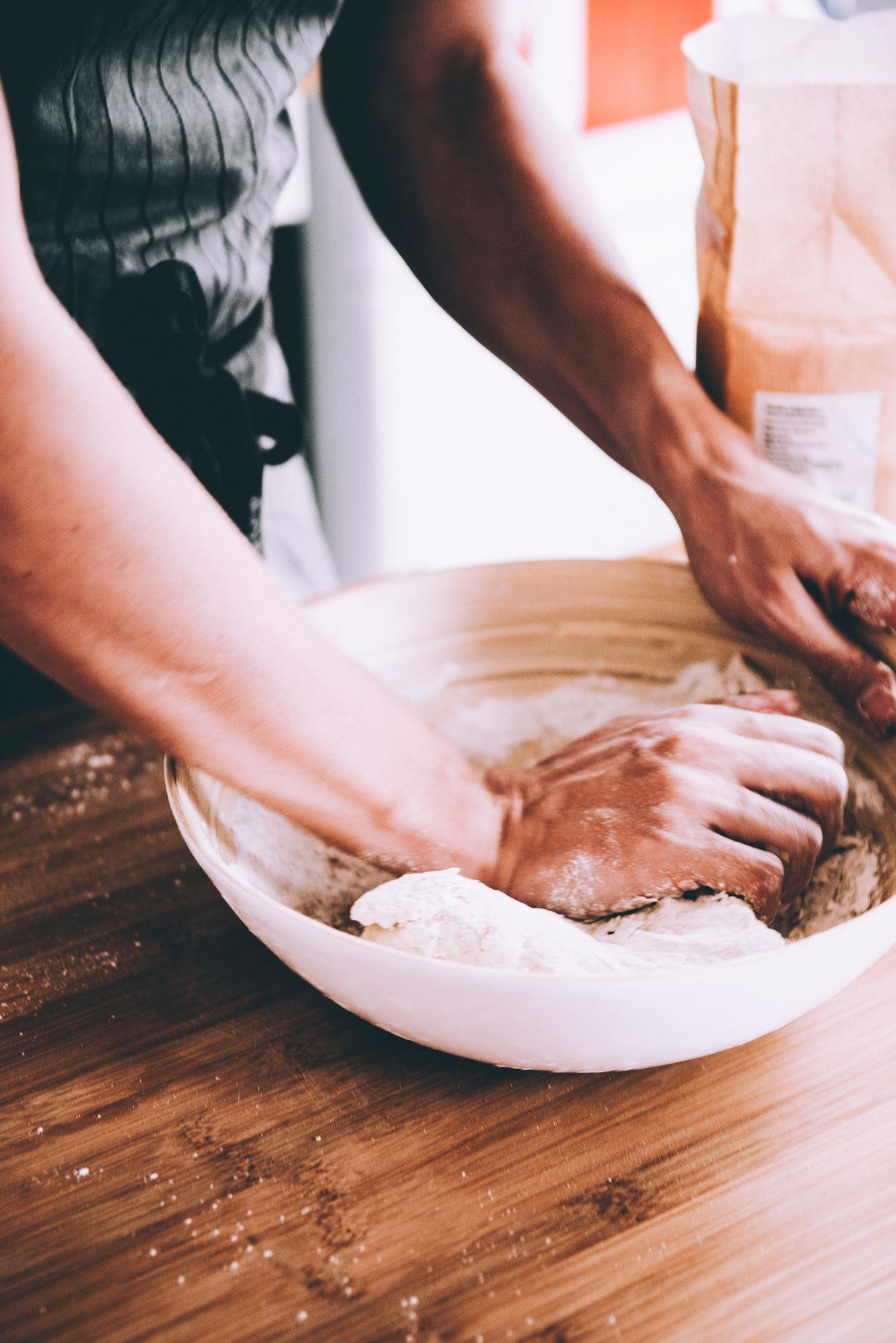Smaller shot: kneading dough in studio kitchen